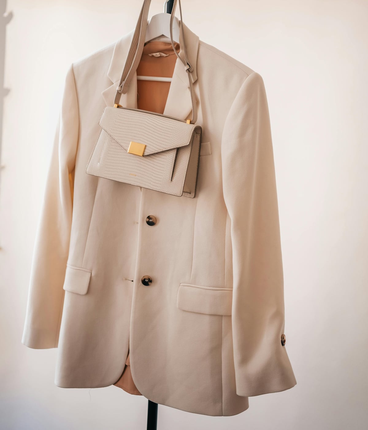A blazer and a purse hanging, symbolizing elegance and quality. With Temera’s RFID technology, every product is accurately tracked, ensuring transparency,